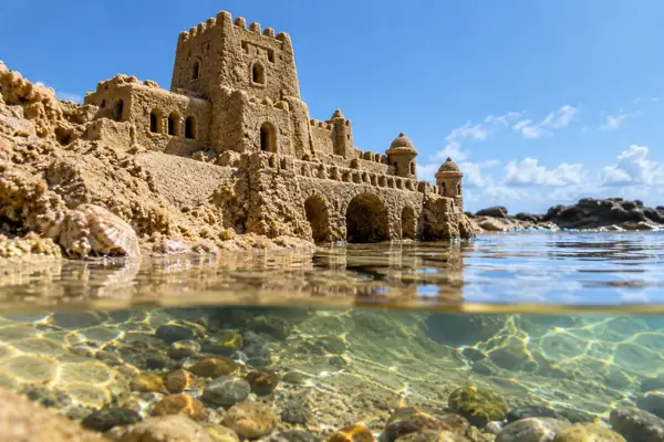 Miniature sand fortress by a tidepool.